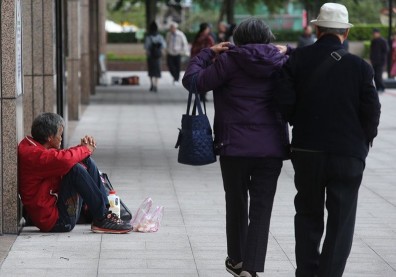 首都中的邊緣人 顫抖瑟縮雨衣抗寒度寒冬
