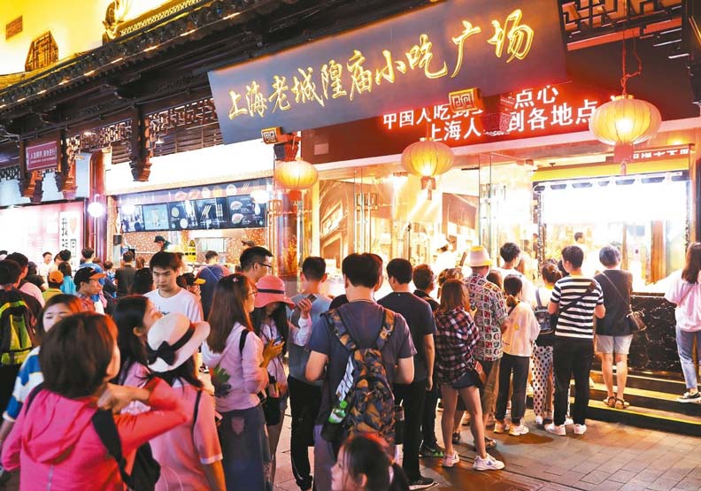 上海「夜間經濟」讓上海更有溫度，圖為豫園夜市特色美食吸引食客大排長龍。中新社