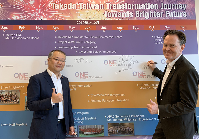 台灣武田董事長暨總經理浅野元以及Thomas Willemsen, Area Senior Vice President of APAC在歷史牆上簽名見證。