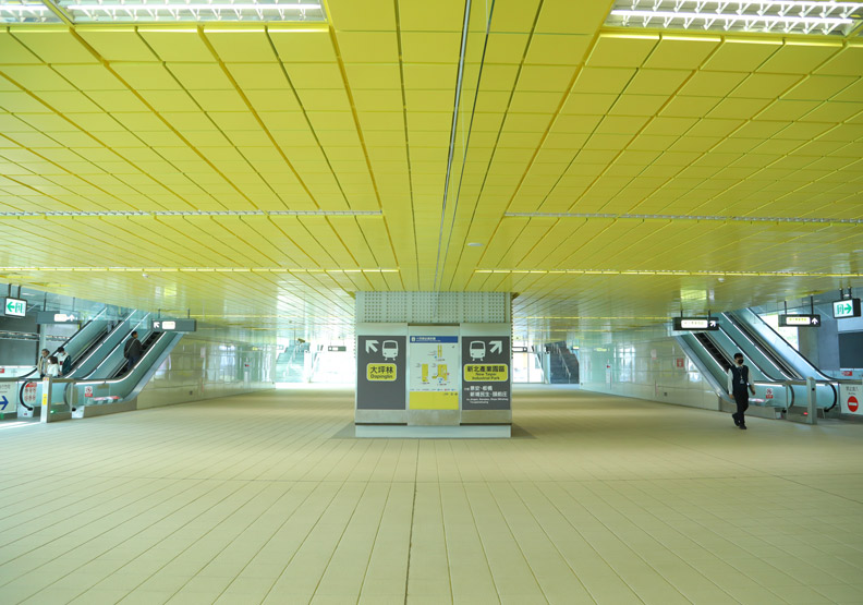 捷運十四張站的天花板全以黃色磚塊狀呈現,讓空間感更加放大。