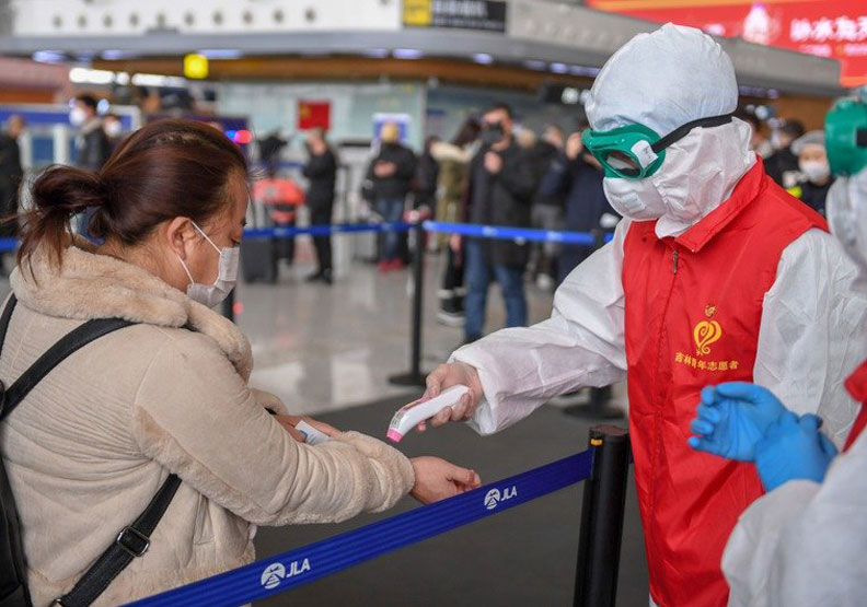 吉林長春龍嘉國際機場工作人員為進出機場人員測溫。新華社