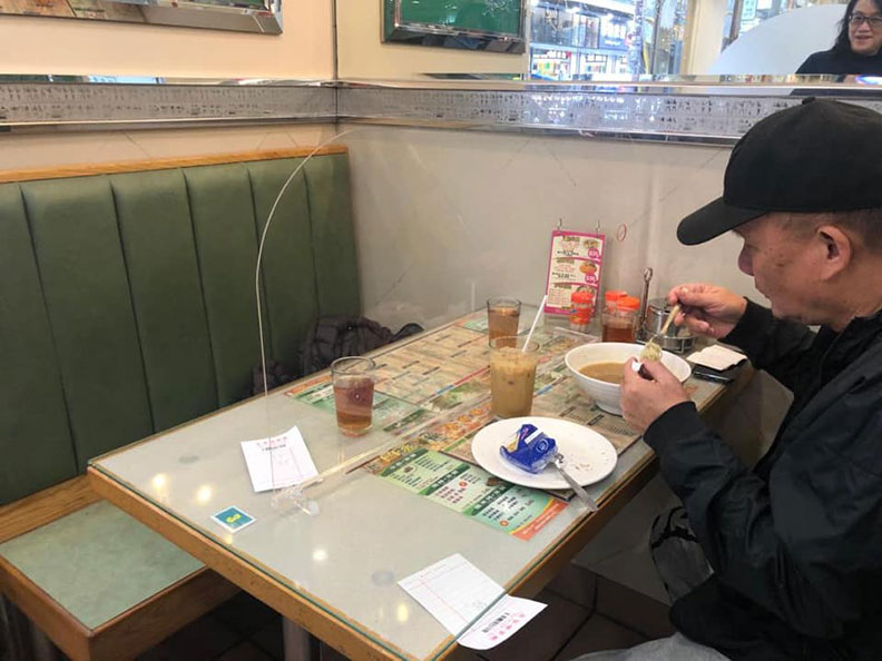 香港一間茶餐廳在陌生客人之間設有塑膠隔板隔開,是餐廳可仿效的作法之一;取自PLAY HARD玩硬臉書社團。