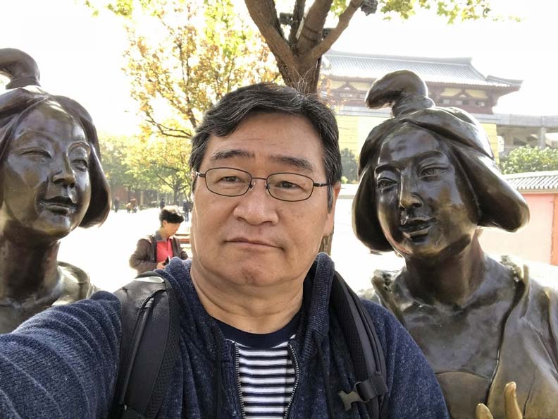 在西安大雁塔寺外,與2位大唐宮女們自拍的王浩一。