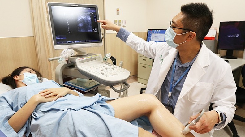 亞洲大學附屬醫院心臟血管外科主任劉殷佐替患者掃靜脈超音波確認血流情形；圖片非當事人，亞洲大學附屬醫院提供。