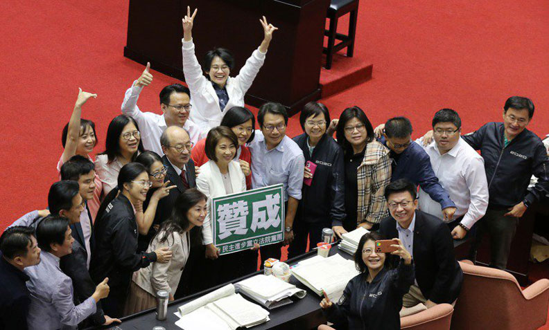 立法院臨時會挑燈夜戰,上午持續審查「國民法官法」,在二讀通過後,民進黨立委在議場內拍照合影慶祝。聯合新聞網提供