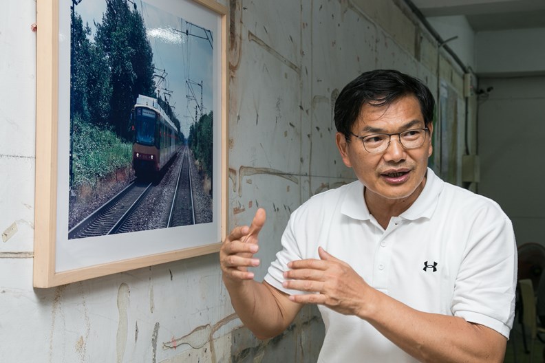 談到城市治理的各種話題,吳益政幾乎都有說不完的故事。(旁為赴德國考察輕軌的照片)
