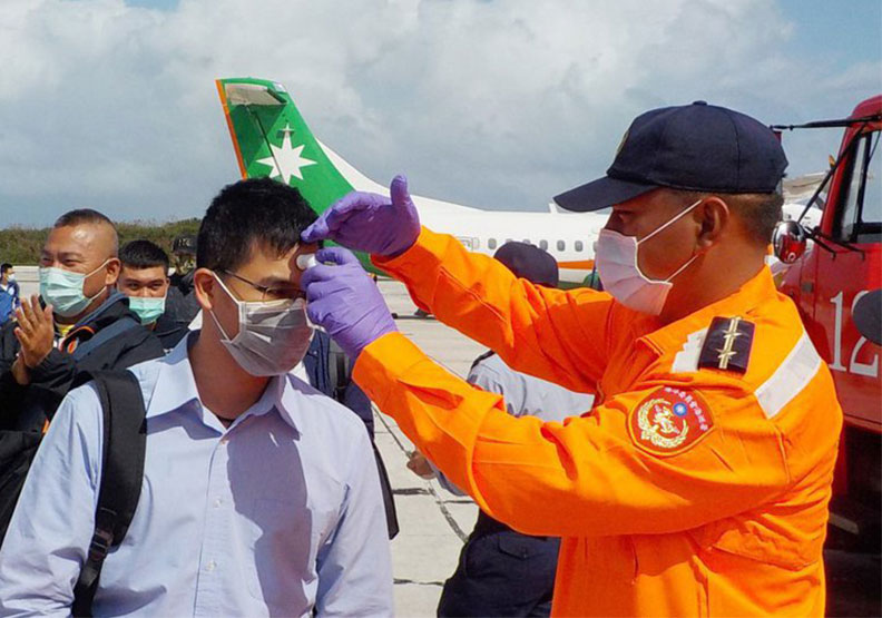 圖／立榮航空由高雄小港機場飛往東沙的軍包機，昨天被香港拒絕進入飛航情報區，圖為東沙島登島人員接受量體溫。取自海巡署東南沙分署