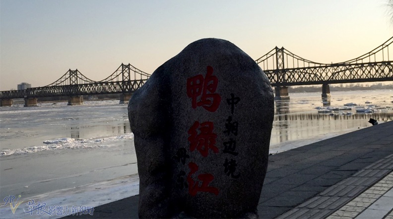 鴨綠江的石頭標誌,前方所見為中朝友誼大橋。