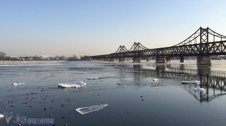 從此方向可見鴨綠江寬廣的河面、友誼大橋全景、對面為朝鮮現代大樓。