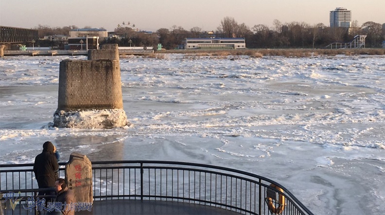 遊人在斷橋觀景台欣賞北韓景觀,北韓的鴨綠江面上結滿冰。
