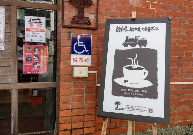 紅磚屋位於宜蘭火車站前,門口迎賓立牌寫著:「請來喝一杯咖啡,火車會等你」。