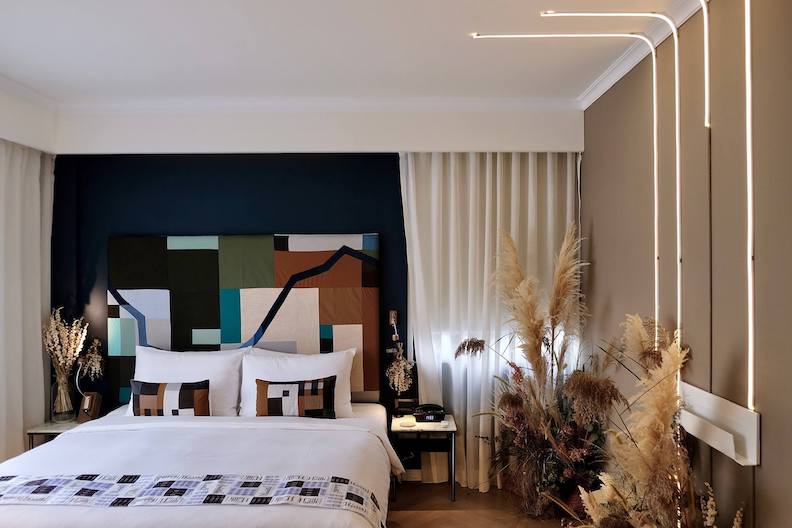 Hiddenspace Room 沉寂客房中裝飾著以回收拼布製成的枕頭與床背板。取自Beautimode