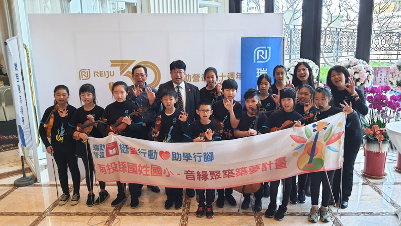 張正岳與偏鄉孩童於記者會上合影。王昱翔攝