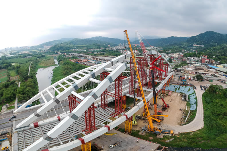 空拍位於橫溪站及龍埔站間的鋼拱橋,是跨三鶯線越跨三峽河的重要建設,總長180公尺,施工過程困難與浩大。三鶯線未來將串聯北桃一小時生活圈,促成重要公共運輸系統間的無縫整合銜接。