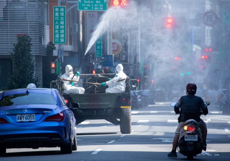 防疫人員正在萬華街頭噴灑消毒藥水。池孟諭攝