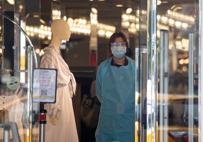 一株病毒阻斷了人潮與錢潮，百貨業者終日等不到顧客上門，口罩也掩蓋不了落寞神情。池孟諭攝