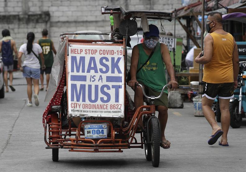 菲律賓民眾高掛標語，提醒口罩的重要。AP