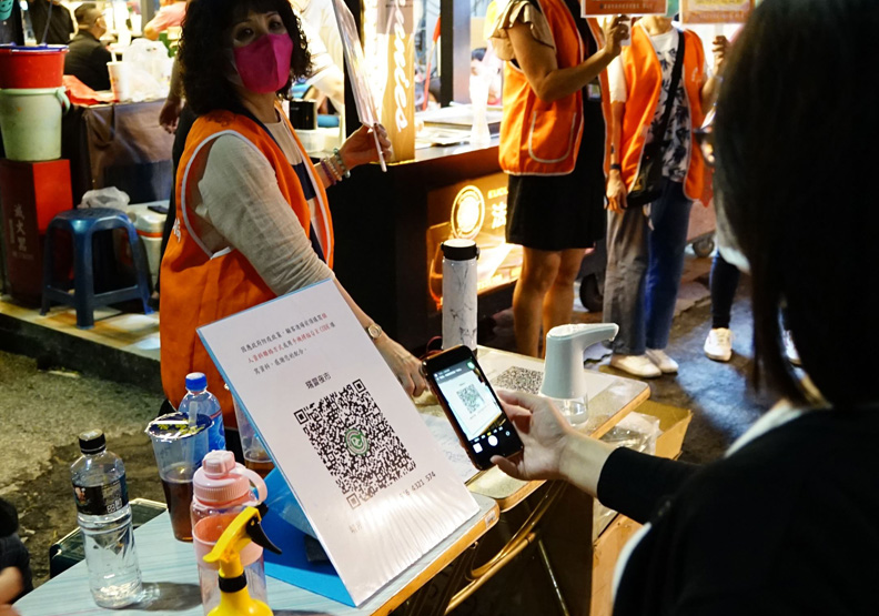 瑞豐夜市管委會在入口執行實聯制與量體溫,高雄市政府提供。