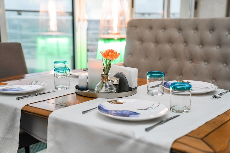 桌旗統整餐具，托盤則放在桌子中央統整花朵和調料瓶。（圖片來源／Shutterstock）