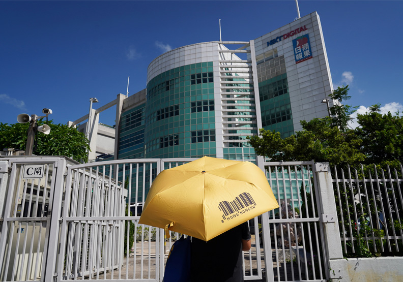 圖／香港蘋果日報大樓前支持者撐著黃色雨傘的身影。達志影像