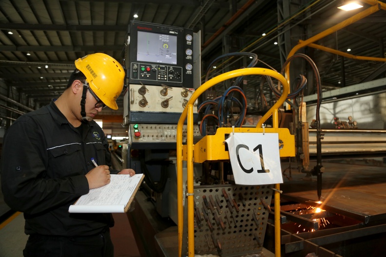 機台旁的產線人員配有平板電腦,並隨時紀錄製程數據。