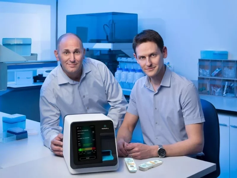 以色列生技業者MeMed共同創辦人伊登博士(Eran Eden;右)和奧維德醫生/博士(Kfir Oved;左)。他們開發出分辨細菌或病毒感染的15分鐘檢測法,在他們前面的就是MeMed BV™。相片取自於網路,由本文作者提供