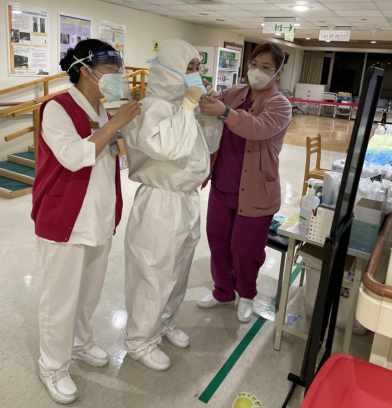 病房護理師協助同仁穿隔離衣。照片來源:黃馨頤。
