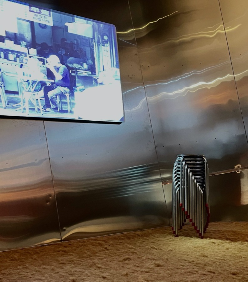 觀眾能坐在遠從台灣運來的白鐵椅凳,地面鋪設的則是大片菜瓜布,這款生活用品是田中央模型的常用素材。田中央提供。