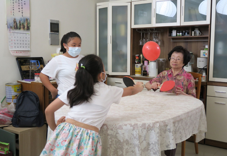 孫女們陪奶奶玩氣球乒乓球,讓奶奶動手動眼又動腦。