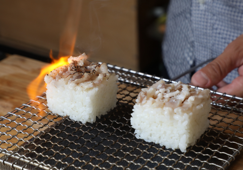 在有機稻米飯上，以熊熊火光烤過Silaw，讓黃瀚這道料理在慢食節上相當「吸睛」且深受歡迎。張智傑攝。