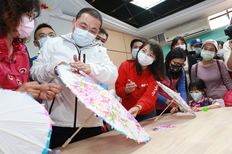 淡水館開幕時新北客家事務局長林素琴(中)陪同侯市長與小朋友共同DIY體驗客家花布傘製作。