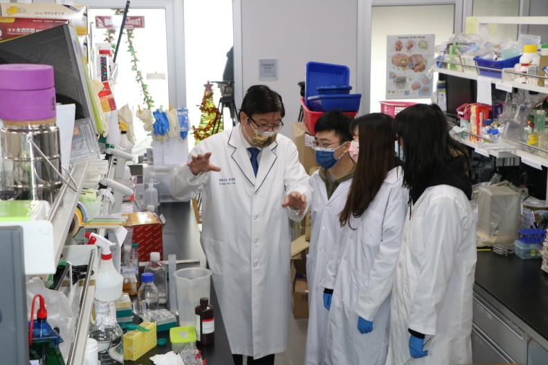 中國醫藥大學校長洪明奇院士（左一）指導研究生做研究的要領︒
