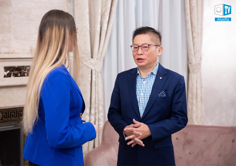 在烏克蘭10多年的沈良哲(右)常受當地媒體採訪其經商之道。沈良哲提供